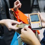 anonymous-woman-paying-in-shop